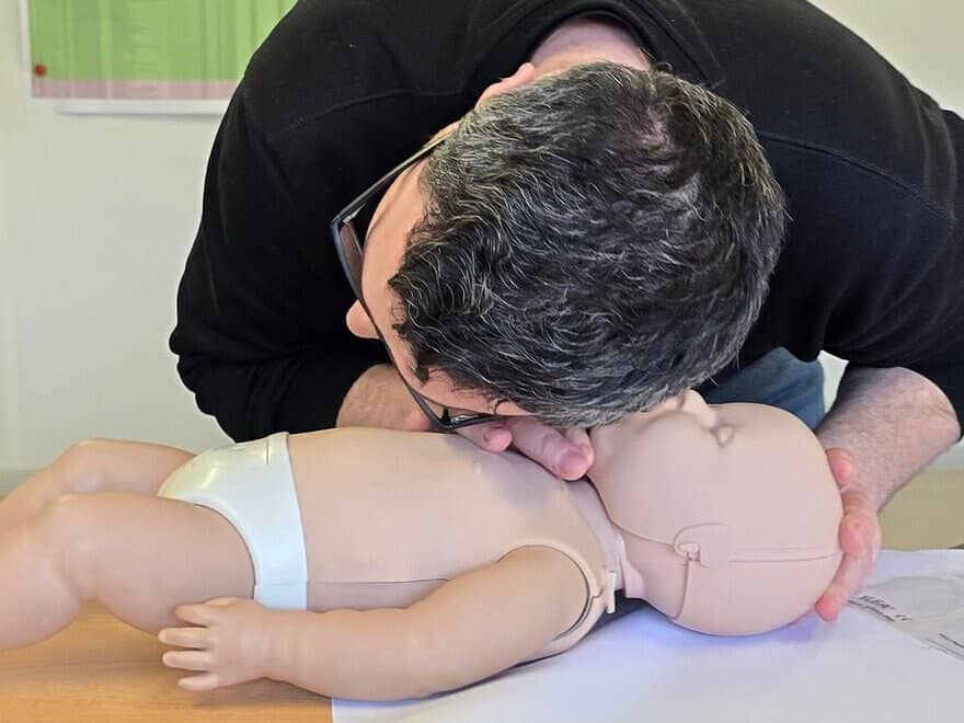 Formateur CNFSE réalisant un bouche-à-bouche sur mannequin nourrisson lors d’une session secourisme bébé